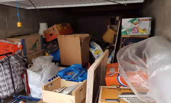 Garage saturé de cartons, de sacs et de meubles empilés jusqu’au plafond